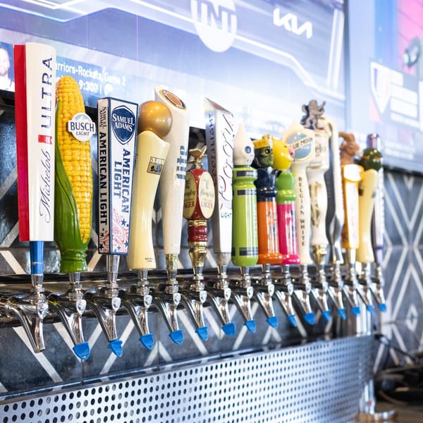 A row of various beer taps, including Michelob Ultra, Busch Light, and Samuel Adams, at Mister B's Pizza & Wings.